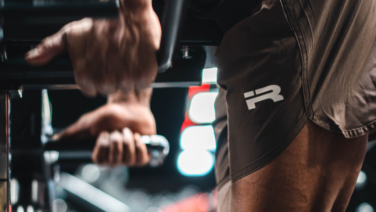 Male athlete training in brown Iron Rebel Tech Shorts at the gym.