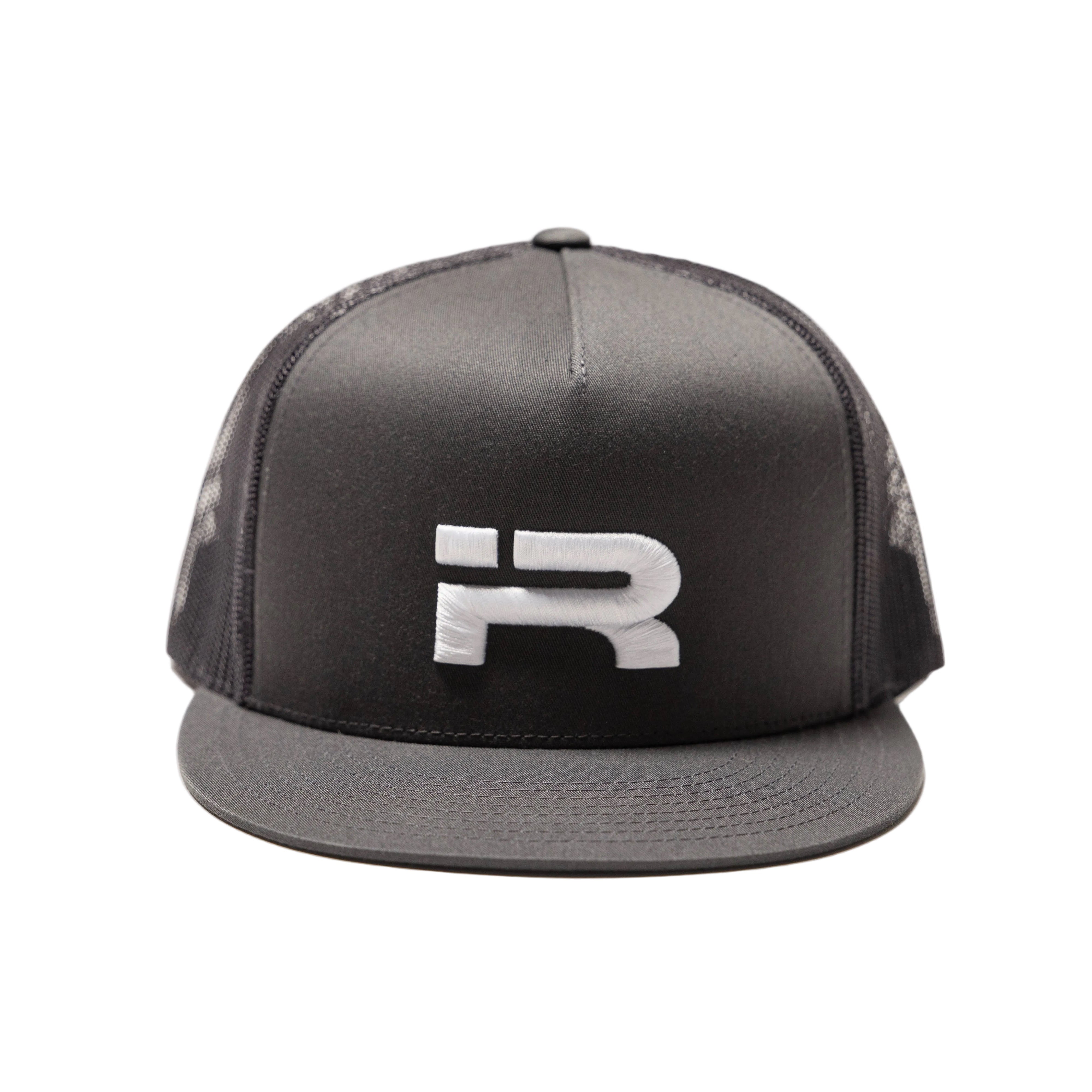A charcoal trucker-style cap with a structured front panel, black mesh back, and a flat brim, featuring a large white stylized 'R' logo on the front. The cap is photographed against a clean, light off-white studio background.